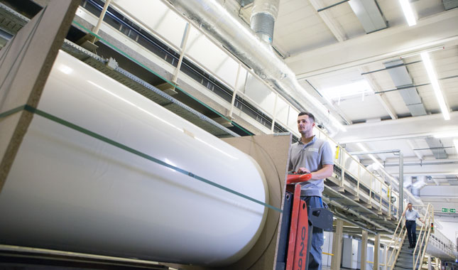 Druckmedien nachhaltig wirtschaften - Gabelstapler mit weisser Jumborolle vor Produktionsanlage 