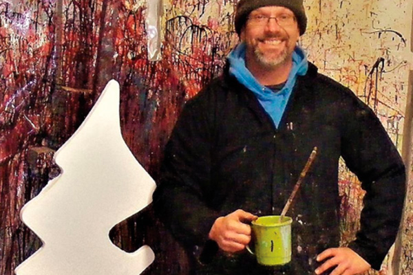 Canvas : Artiste avec un pot de peinture à la main devant une peinture colorée